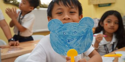 Student showing his picture at drawing class